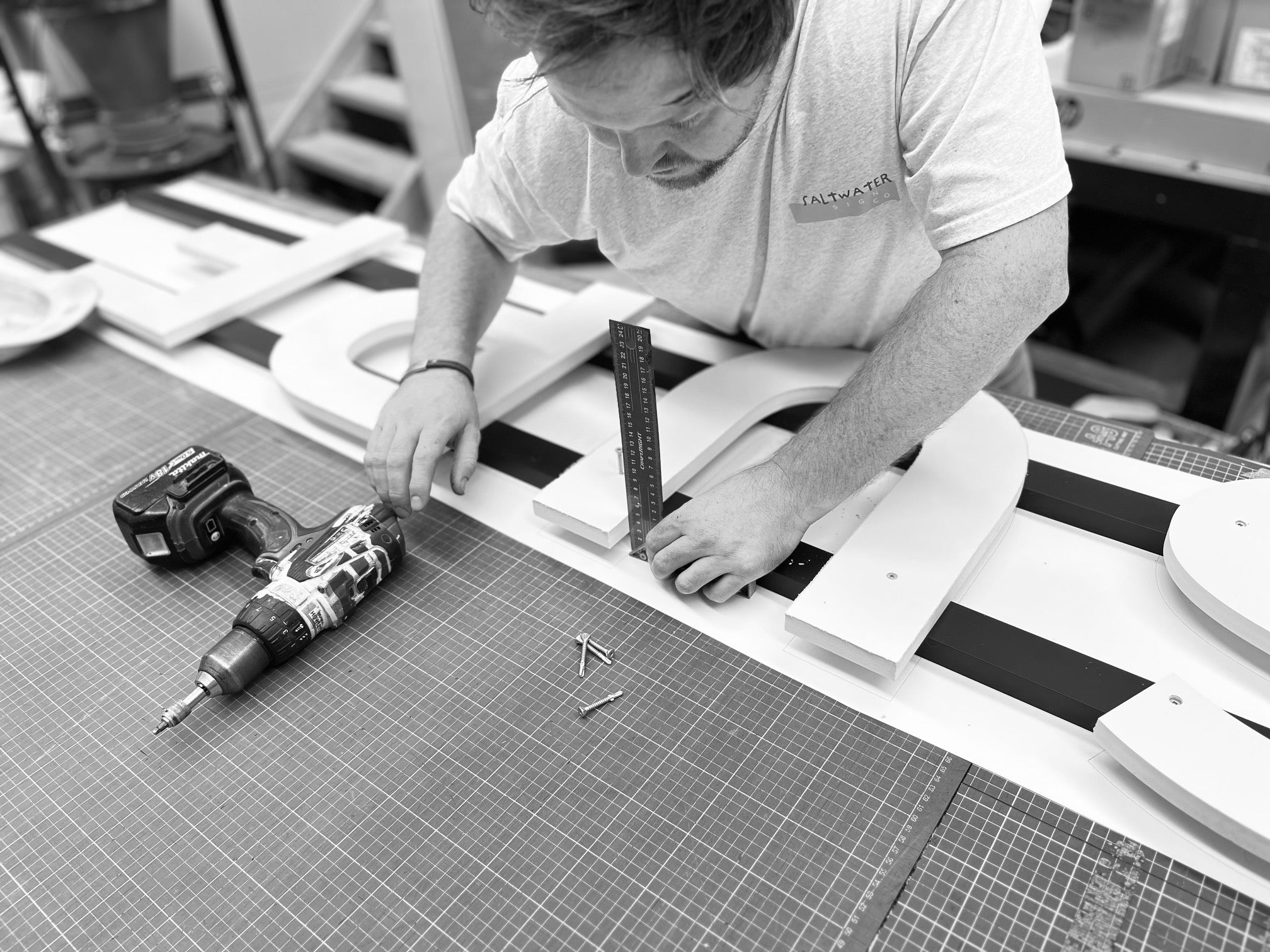 Signwriter working on 3D Lettering sign at Saltwater Sign Co black and white